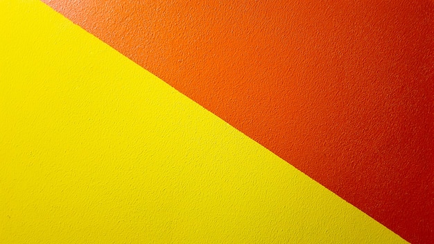 Foto fondo de grunge abstracto de textura de pared pintada de rojo y amarillo con espacio de copia. patrón geométrico abstracto en la pared. la pared está dividida en cenefas de diferentes colores.