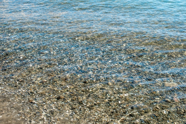 Foto fondo de guijarros de mar bajo el agua en la playa de guijarros bajo el agua clara textura de guijarros submarinos