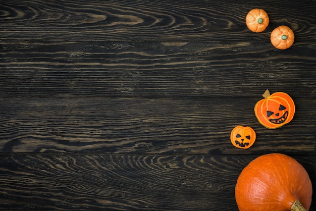 Foto fondo de halloween con calabaza y galletas comida plana en mesa vintage de madera para hallowen