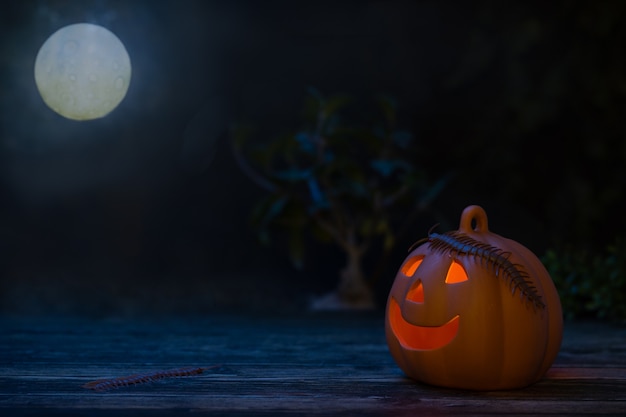 Fondo de Halloween con calabaza iluminada en la noche negra