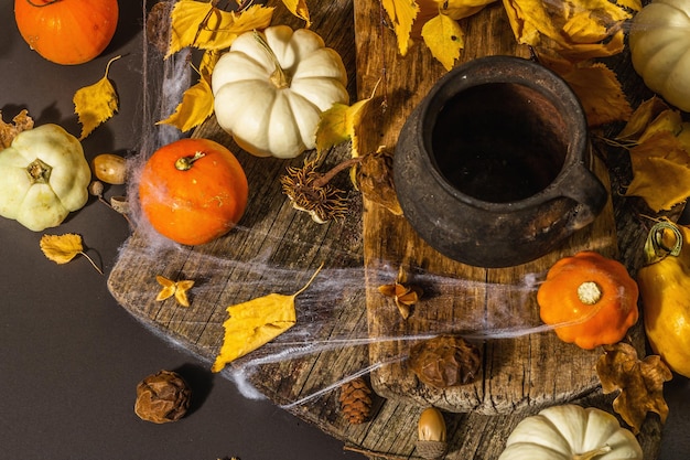 Fondo de Halloween. Calabazas, arañas, telarañas, murciélagos, fantasmas. Símbolos festivos, hojas de otoño, olla de pociones de bruja. La disposición atmosférica, fondo negro.