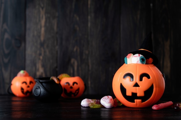 Fondo de Halloween con calabazas jack o lanterns con dulces sobre fondo de madera negra