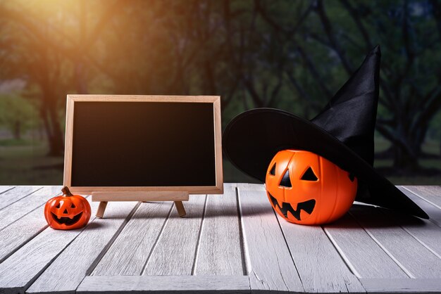 Fondo de Halloween. Spooky calabaza, pizarra en el piso de madera y bosque oscuro.