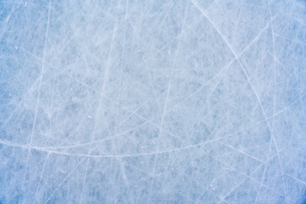 Fondo de hielo con marcas de patinaje y hockey, textura azul de la superficie de la pista con arañazos