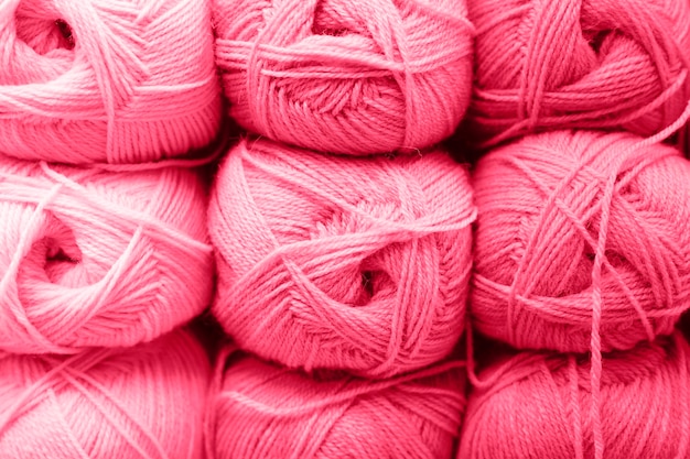 Fondo de hileras de madejas de hilo de lana esponjoso para tejer colores de tono púrpura rosa rojo suave tonificados en el color de tendencia magenta viva del año 2023