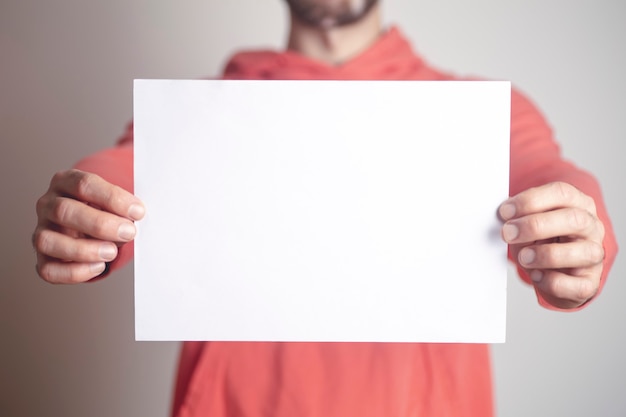 Un fondo de hoja de papel en blanco en manos de un joven.