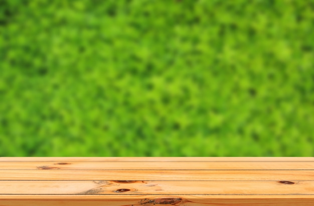 Fondo de hojas verdes con exhibición de productos de mesa de madera lisa