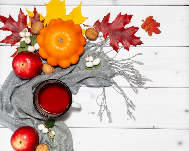 Foto fondo horizontal de otoño brillante con manzanas rojas de calabaza naranja, nueces, taza de té, vista plana superior