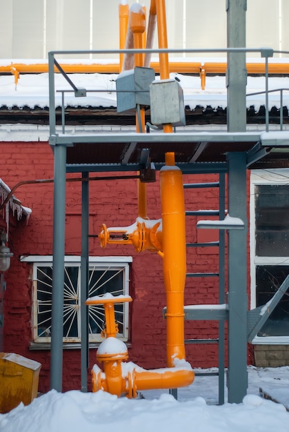 Fondo industrial - fragmento de un gasoducto de fábrica con válvulas al aire libre en invierno