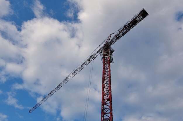 Fondo industrial con grúa de construcción sobre azul cielo nublado