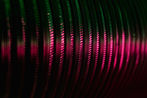 Fondo industrial de neón Textura surcada Ruedas dentadas de acero en relieve Desenfoque degradado de color rosa verde fluorescente resplandor en superposición abstracta acanalada curvada oscura