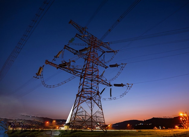 Foto fondo industrial del paisaje nocturno de la torre de electricidad de alto voltaje