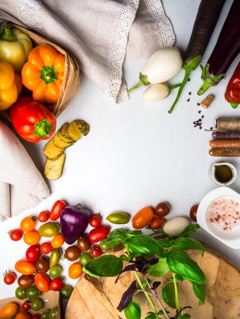 Fondo de ingredientes de comida italiana con verduras, sal, especias y hierbas, queso, aceite de oliva, albahaca, pimientos, berenjena y tomates, espacio de copia