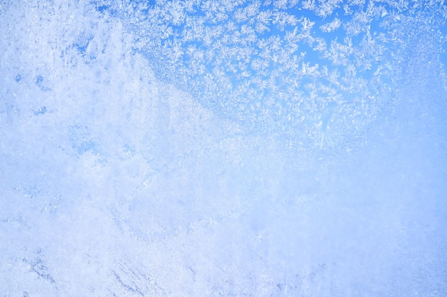 Fondo de invierno abstracto Frost en una ventana congelada contra el cielo azul