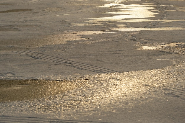 Fondo de invierno al atardecer. La textura de la nieve blanca sobre el hielo.