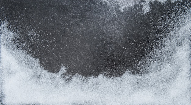 Fondo de invierno. Blanca nieve sobre textura de piedra oscura