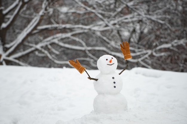 Fondo de invierno con copos de nieve y muñeco de nieve. Muñeco de nieve feliz con cajas de regalo en invierno