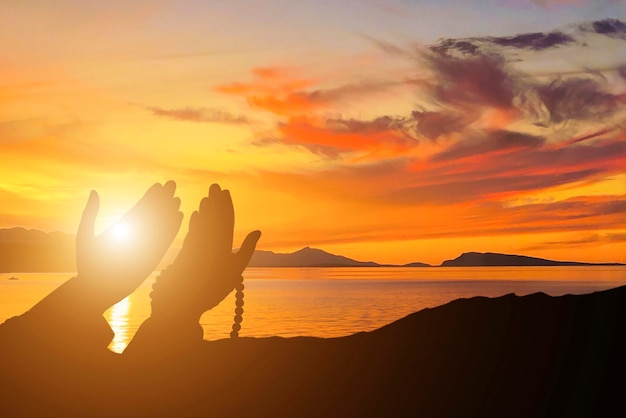 Foto fondo islámico con persona rezando con puesta de sol
