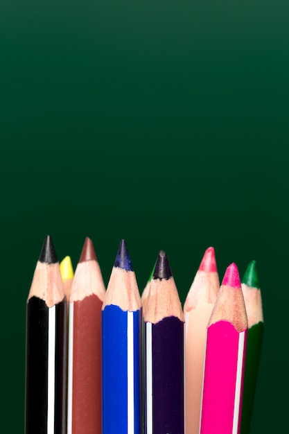 Fondo de lápices de colores sobre papel verde