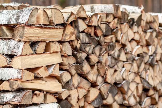 Fondo de leña de madera picada para encender y calentar la casa Primer plano. una pila de leña con leña apilada. la textura del abedul. bandera