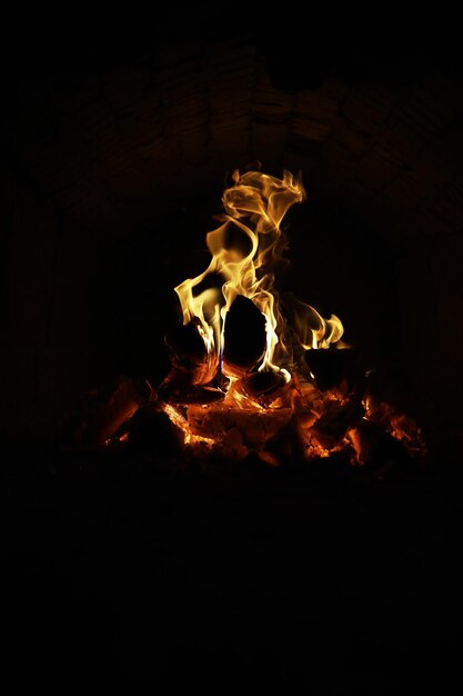 Foto fondo de la llama en el horno lenguas de fuego en una chimenea de ladrillo textura de fuego