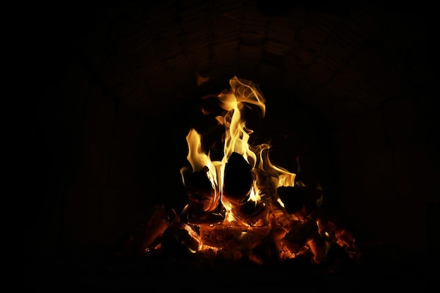 Fondo de la llama en el horno Lenguas de fuego en una chimenea de ladrillo Textura de fuego