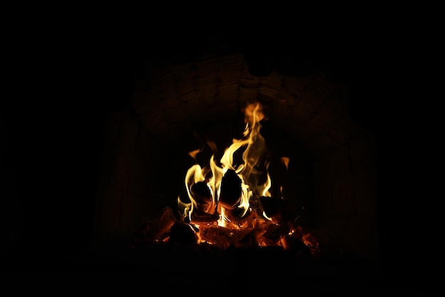 Fondo de la llama en el horno Lenguas de fuego en una chimenea de ladrillo Textura de fuego