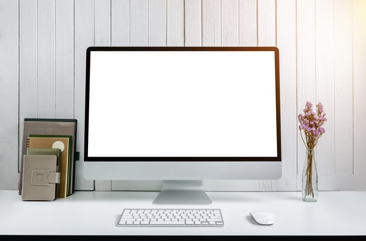 Foto fondo del lugar de trabajo con la computadora de escritorio moderna de la pantalla en blanco. vintage de madera blanco negro