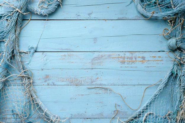 Un fondo de madera azul claro con redes de pesca en los lados que crea un espacio vacío para el texto o d