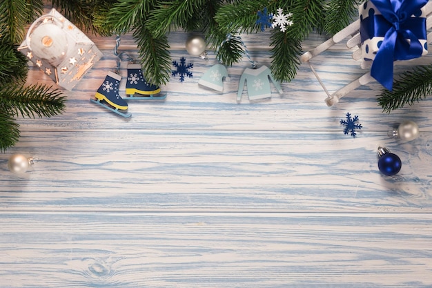 Fondo de madera azul de Navidad con cajas de regalo de abeto linterna y trineo decorativo