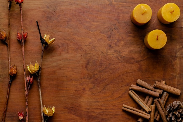 Fondo de madera cafe con canela velas y flores secas