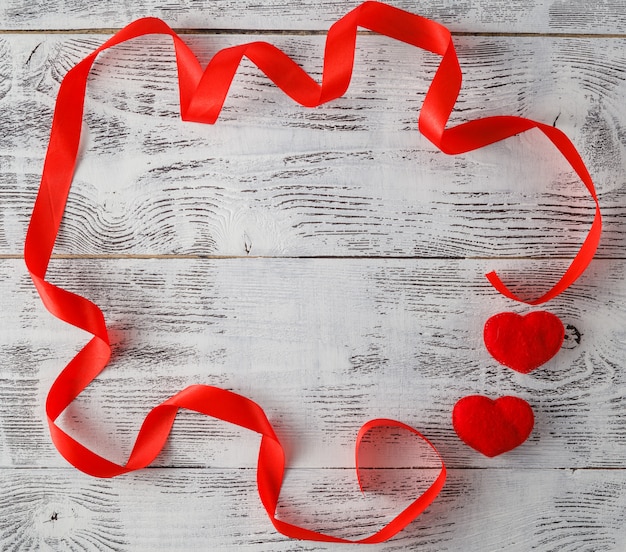 Fondo de madera con cinta roja y corazones de caramelo