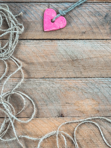 Foto fondo de madera decorado con un corazón artesanal para san valentín