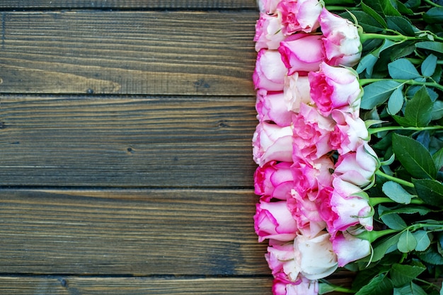 Fondo de madera con flores de color rosa.