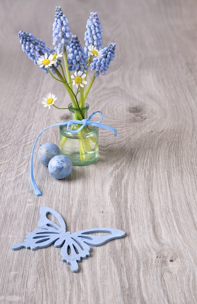 Fondo de madera con flores de primavera y huevos de codorniz