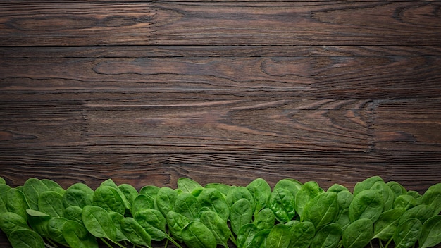 Fondo de madera con hojas de espinaca baby.