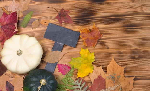 Fondo de madera, hojas secas de otoño y calabazas.