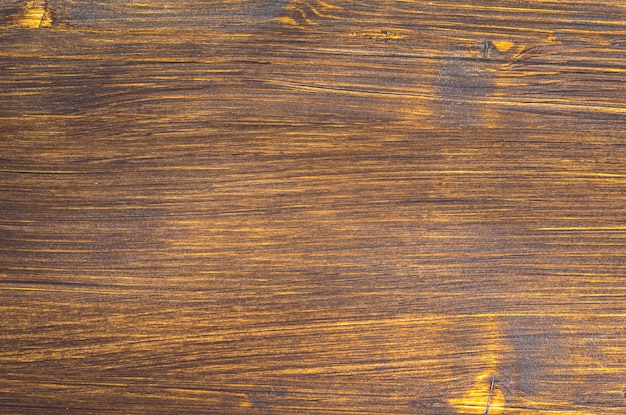 Fondo de madera natural oscuro pintado con tinte de madera para tonificar el marrón.