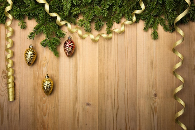 Fondo de madera de Navidad con adornos y cinta dorada de abeto