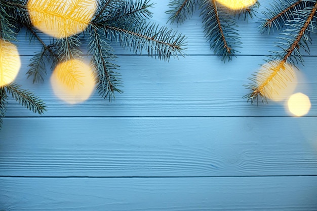 Fondo de madera de Navidad y año nuevo con ramas de abeto azul y luces espacio de copia