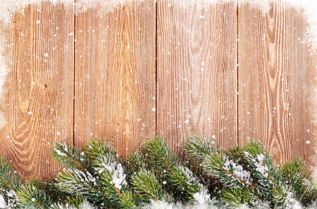 Fondo de madera de la Navidad con el árbol de abeto de la nieve.