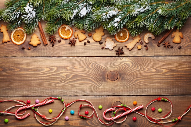 Fondo de madera de Navidad con especias de abeto de nieve y galletas de jengibre