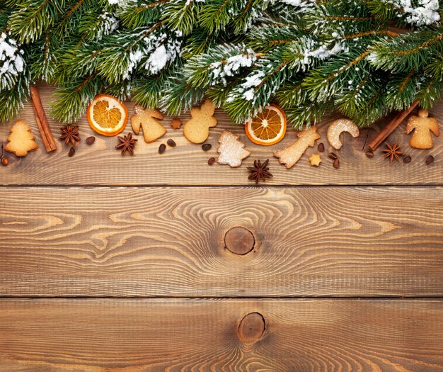 Fondo de madera de Navidad con galletas de jengibre de especias de abeto de nieve