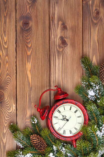 Fondo de madera de Navidad con reloj nieve abeto