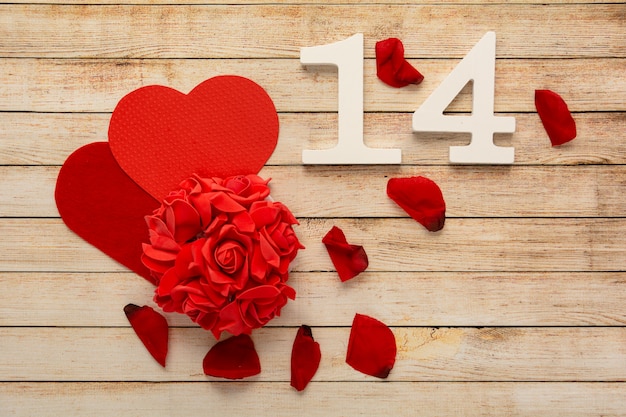 Fondo de madera con pétalos, flores, corazones y números de madera del 14 de febrero. El concepto de San Valentín.