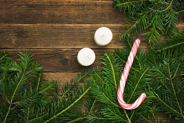 Fondo de madera ramas de abeto dulces y velas concepto de Navidad