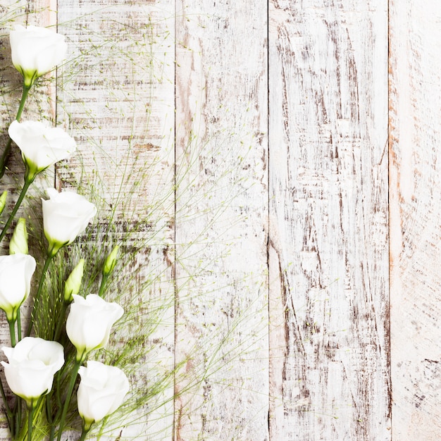 Fondo de madera con ramo de flores blancas.