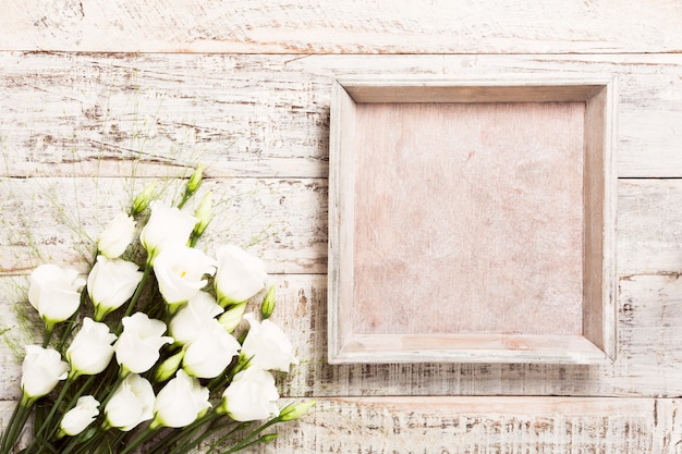 Fondo de madera con ramo de flores blancas.