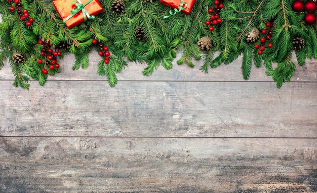 Fondo de madera rústica con adornos navideños Ramas de pino perenne de vacaciones de Navidad y bayas rojas sobre fondo de madera Espacio de copia Maqueta rústica de Navidad