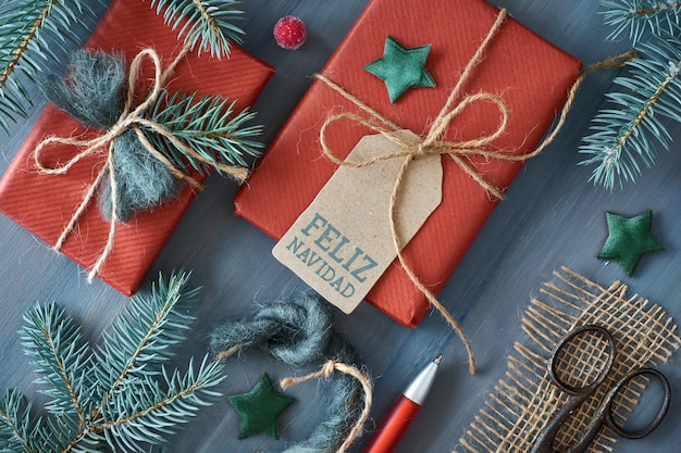 Fondo de madera rústica con ramas de abeto y regalos de Navidad regalo envuelto en papel rojo